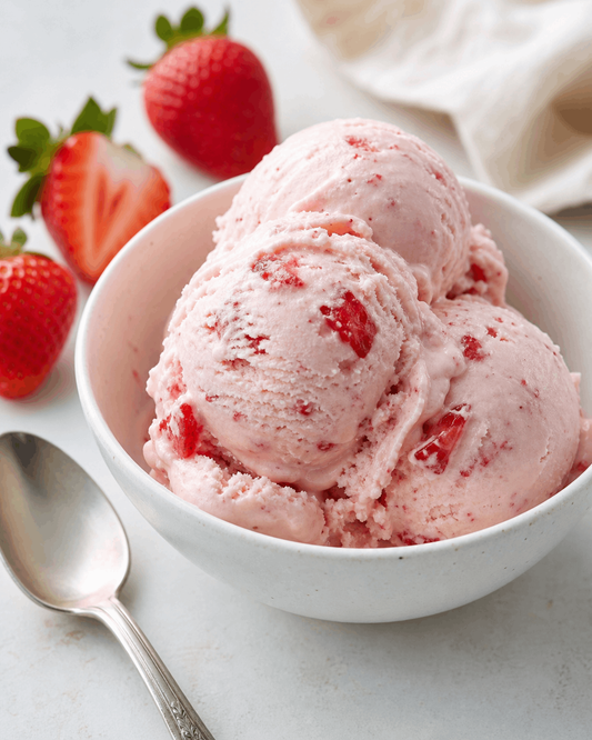 Strawberry cottage cheese ice cream served in a white bowl with fresh strawberries